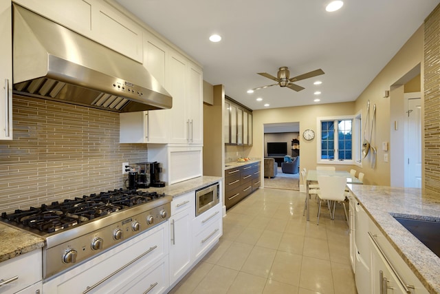 kitchen featuring light tile patterned flooring, recessed lighting, stainless steel appliances, ventilation hood, and decorative backsplash