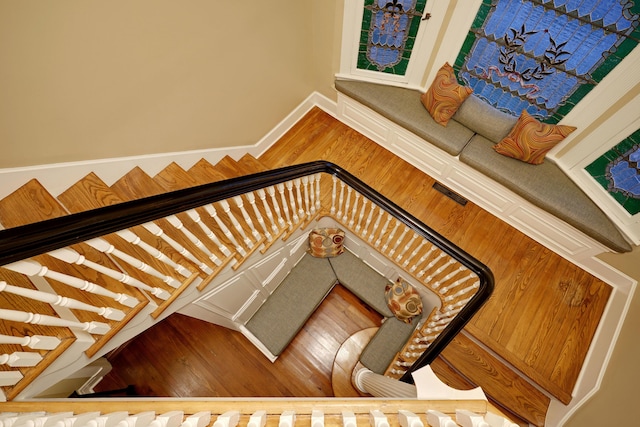 staircase with visible vents, baseboards, and wood finished floors