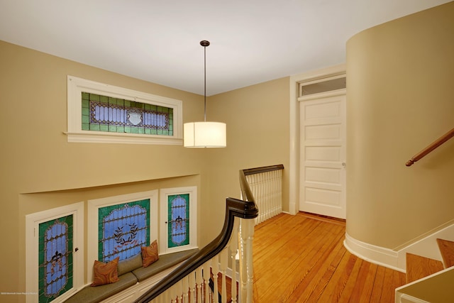 interior space with stairway, baseboards, wood finished floors, and an upstairs landing