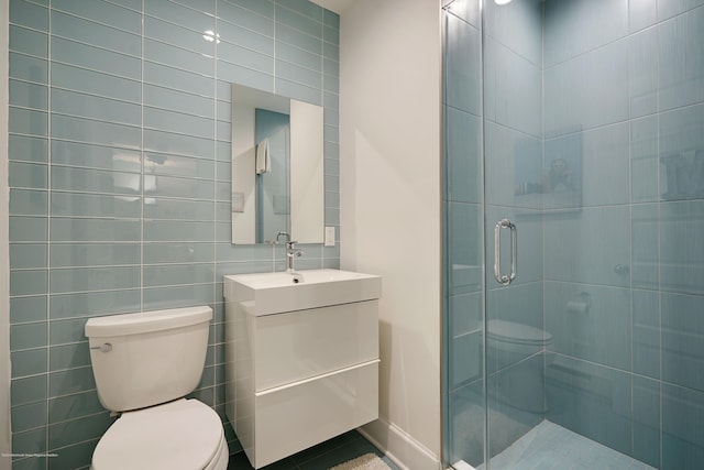 full bath featuring vanity, a shower stall, toilet, and tile walls