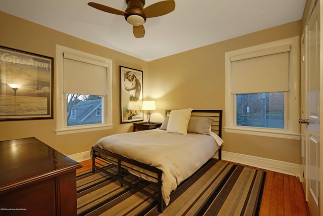 bedroom featuring a ceiling fan, baseboards, and wood finished floors