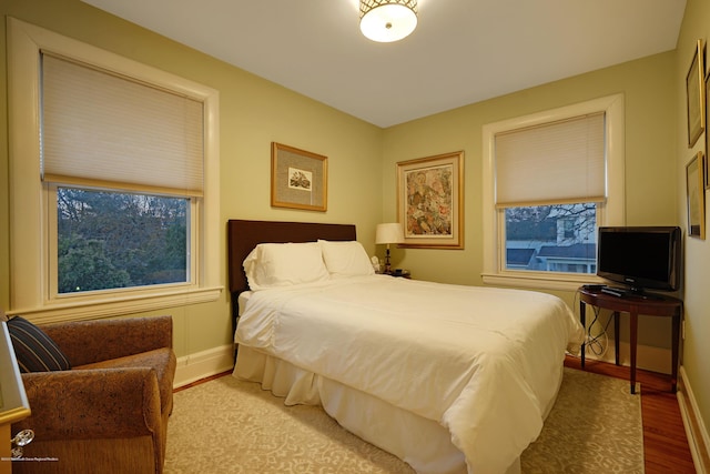 bedroom featuring baseboards and wood finished floors