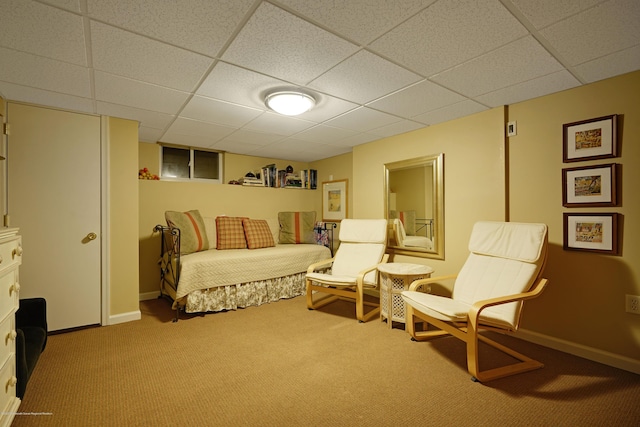 sitting room featuring carpet, a drop ceiling, and baseboards