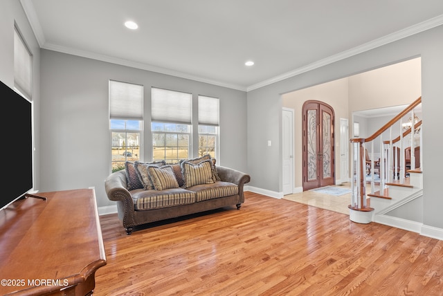 living room with baseboards, stairway, wood finished floors, and crown molding