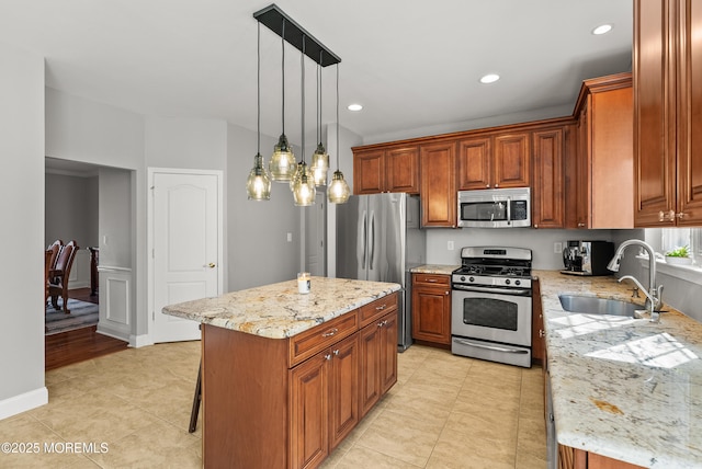 kitchen featuring stainless steel appliances, brown cabinetry, a sink, and light stone countertops