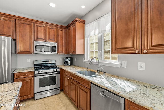 kitchen with light tile patterned floors, light stone counters, recessed lighting, a sink, and appliances with stainless steel finishes