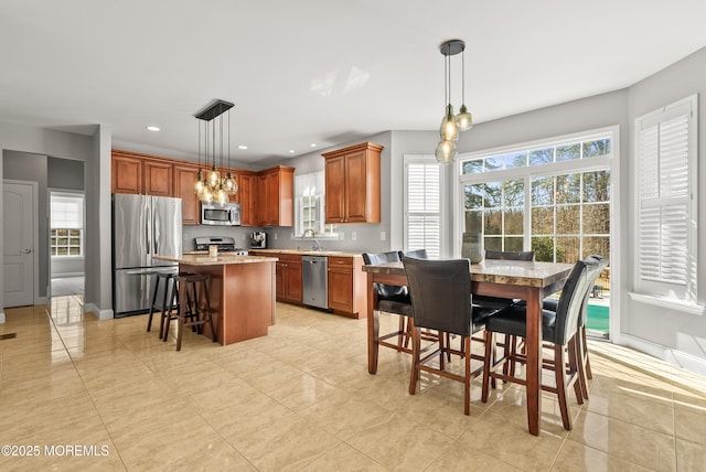 kitchen with a center island, stainless steel appliances, recessed lighting, a sink, and a kitchen breakfast bar