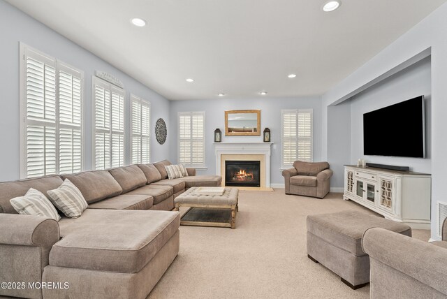 carpeted living room featuring baseboards, a glass covered fireplace, and recessed lighting