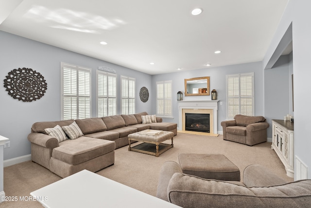 living area with light colored carpet, recessed lighting, visible vents, and a glass covered fireplace