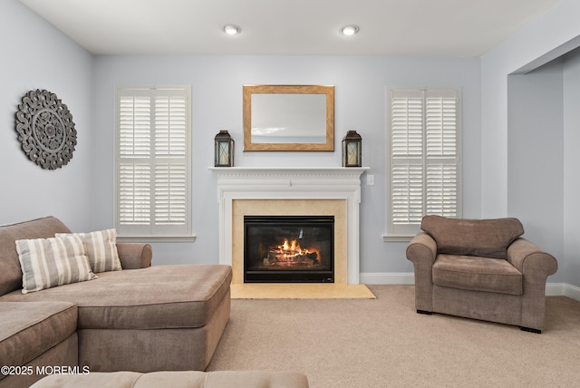 carpeted living room featuring recessed lighting, a glass covered fireplace, and baseboards