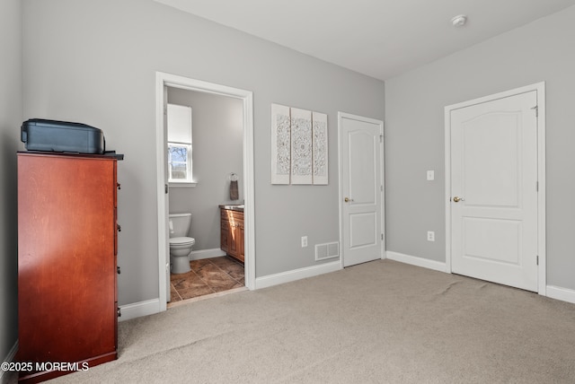 unfurnished bedroom with carpet floors, baseboards, visible vents, and connected bathroom