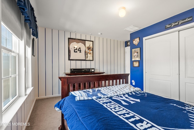 carpeted bedroom featuring a closet and visible vents