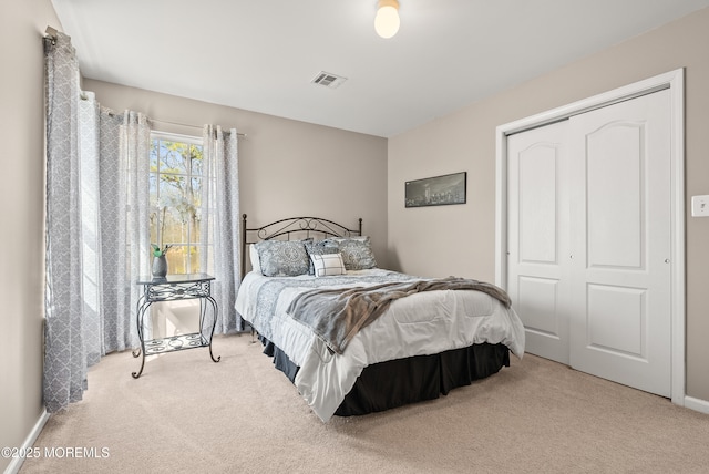 bedroom featuring carpet floors, a closet, visible vents, and baseboards