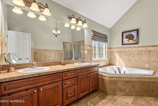 bathroom with lofted ceiling, a sink, a shower stall, and a bath