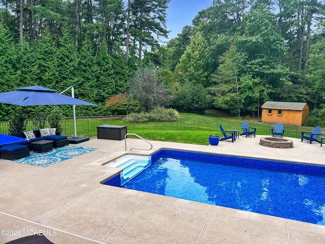 view of swimming pool featuring a fenced in pool, an outdoor living space with a fire pit, a lawn, a patio area, and a fenced backyard