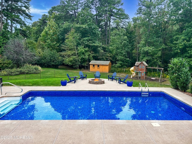 view of pool with an outdoor fire pit, a fenced in pool, fence, an outdoor structure, and a patio area