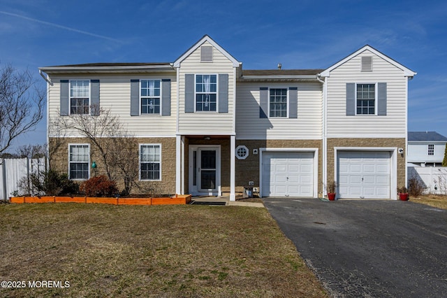 view of front of property featuring a front lawn, driveway, an attached garage, and fence