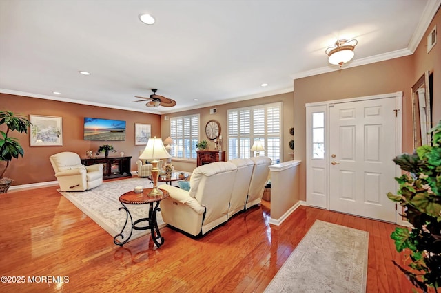 living room with light wood-type flooring, baseboards, crown molding, and recessed lighting