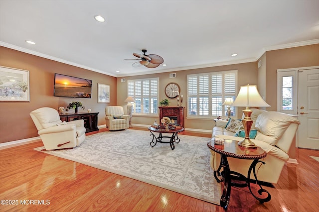 living room with ornamental molding, a fireplace, and wood finished floors