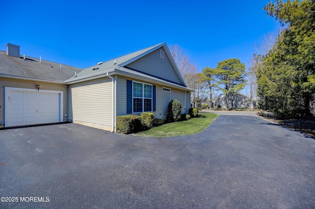 view of property exterior with driveway and an attached garage