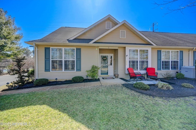 view of front of property with a shingled roof and a front yard