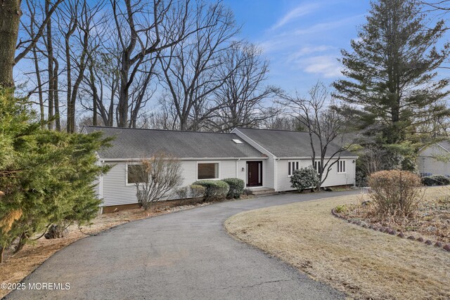 ranch-style home featuring aphalt driveway