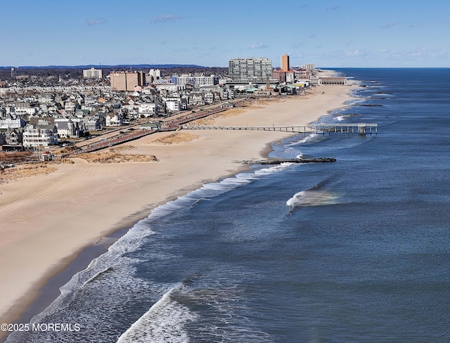 bird's eye view featuring a water view, a view of city, and a beach view