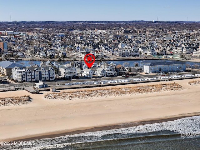 drone / aerial view with a residential view, a water view, and a view of the beach