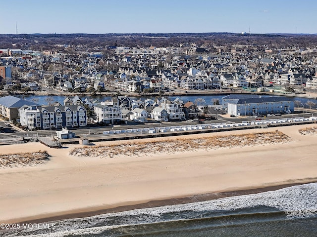 birds eye view of property featuring a view of the beach, a water view, and a residential view