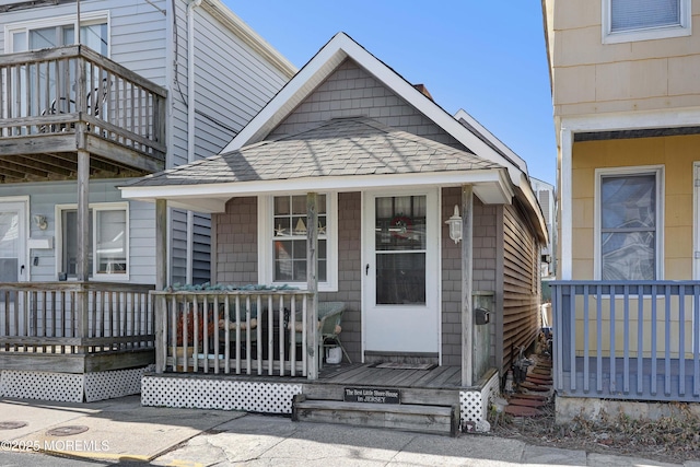 view of front of property featuring a porch and roof with shingles