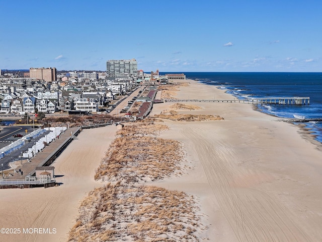 drone / aerial view featuring a water view and a view of the beach