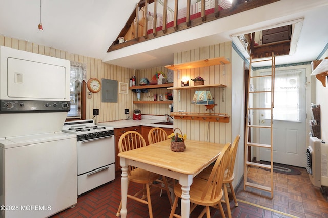 kitchen with stacked washer and clothes dryer, electric panel, open shelves, white gas range oven, and light countertops