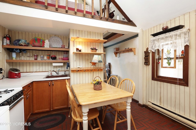 kitchen featuring open shelves, a baseboard radiator, white gas range, brick floor, and a sink