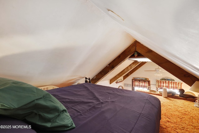 carpeted bedroom with vaulted ceiling with beams