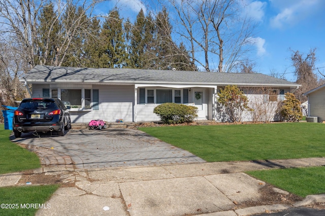 single story home with driveway, a shingled roof, and a front yard