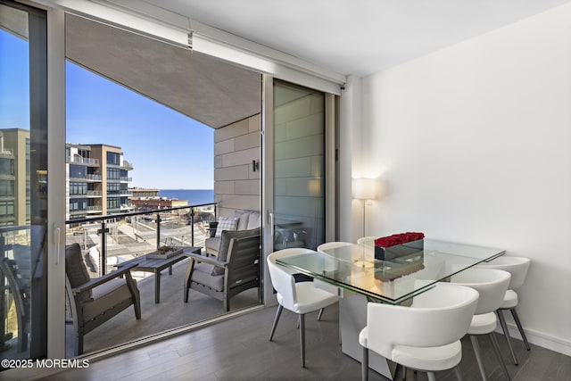 balcony featuring a water view and outdoor dining space