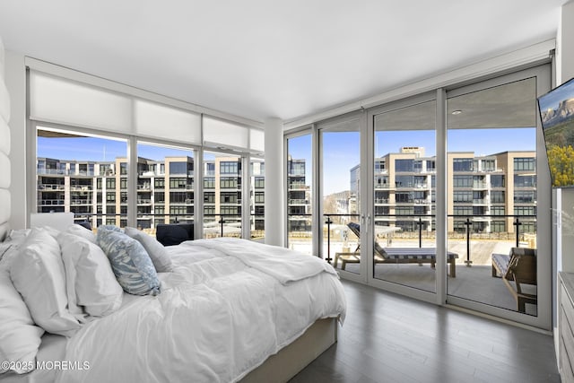 bedroom featuring floor to ceiling windows, wood finished floors, and access to outside