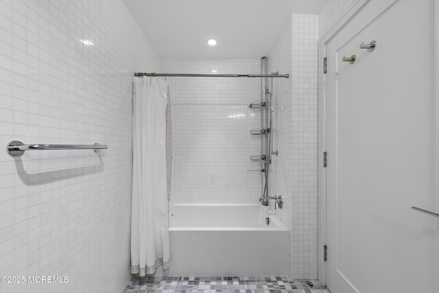 full bathroom with tile walls and shower / bath combo