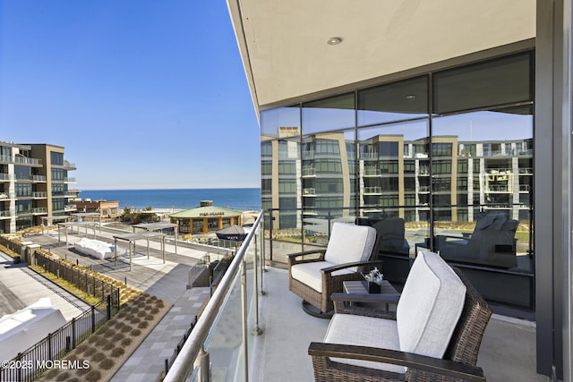 balcony with a water view and an outdoor hangout area