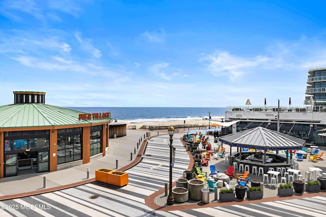 view of home's community featuring a gazebo, a water view, and a beach view