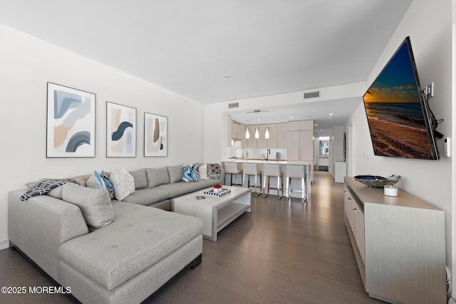 living room with visible vents and dark wood-style floors