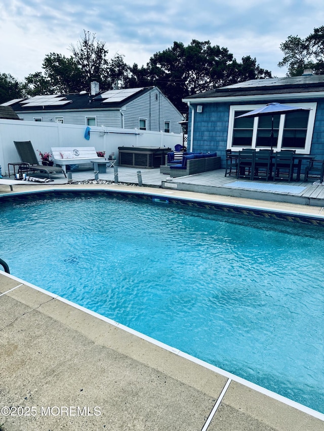 view of swimming pool featuring a hot tub, fence, a fenced in pool, and a patio