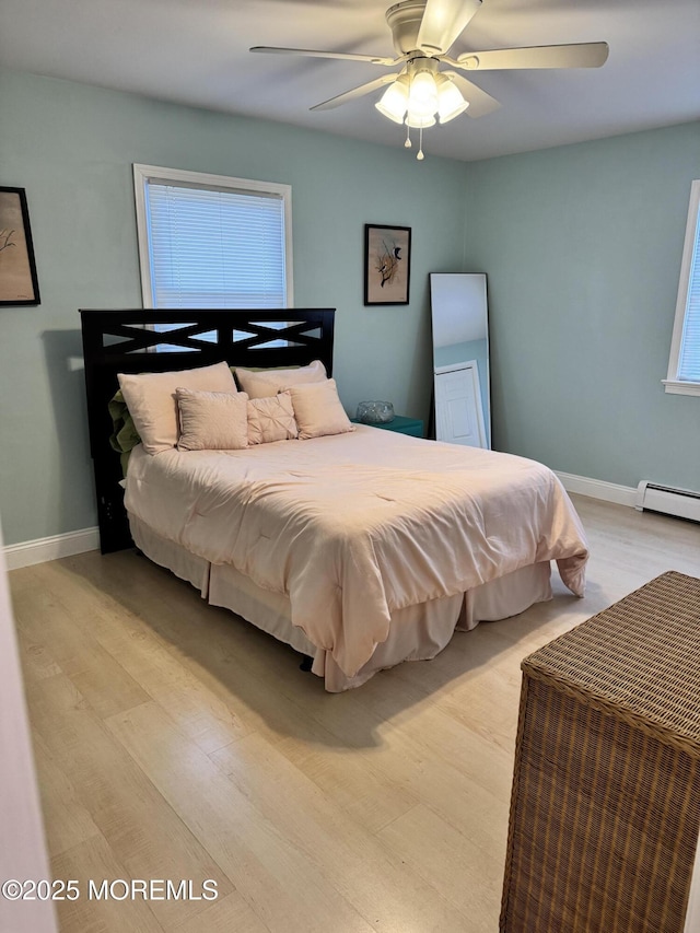 bedroom featuring light wood-style floors, baseboards, and a ceiling fan