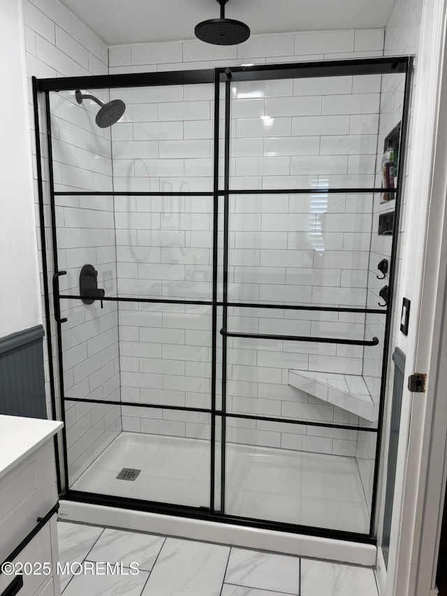 bathroom featuring wainscoting, a shower stall, and vanity