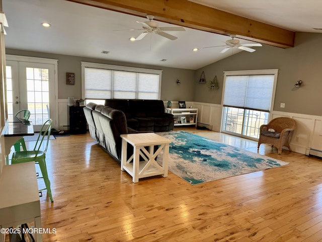 living area featuring lofted ceiling with beams, light wood finished floors, recessed lighting, and wainscoting