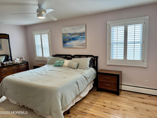 bedroom with light wood-type flooring, baseboard heating, and a ceiling fan