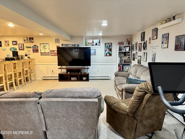 carpeted living room featuring a baseboard radiator, a wainscoted wall, visible vents, baseboard heating, and a bar