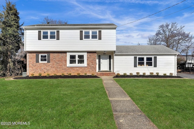 colonial inspired home with a front yard and brick siding