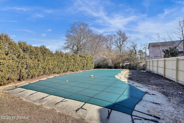 view of swimming pool with a patio area, a covered pool, and fence