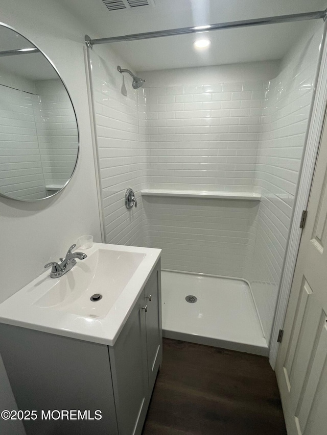 bathroom featuring a stall shower, wood finished floors, and vanity